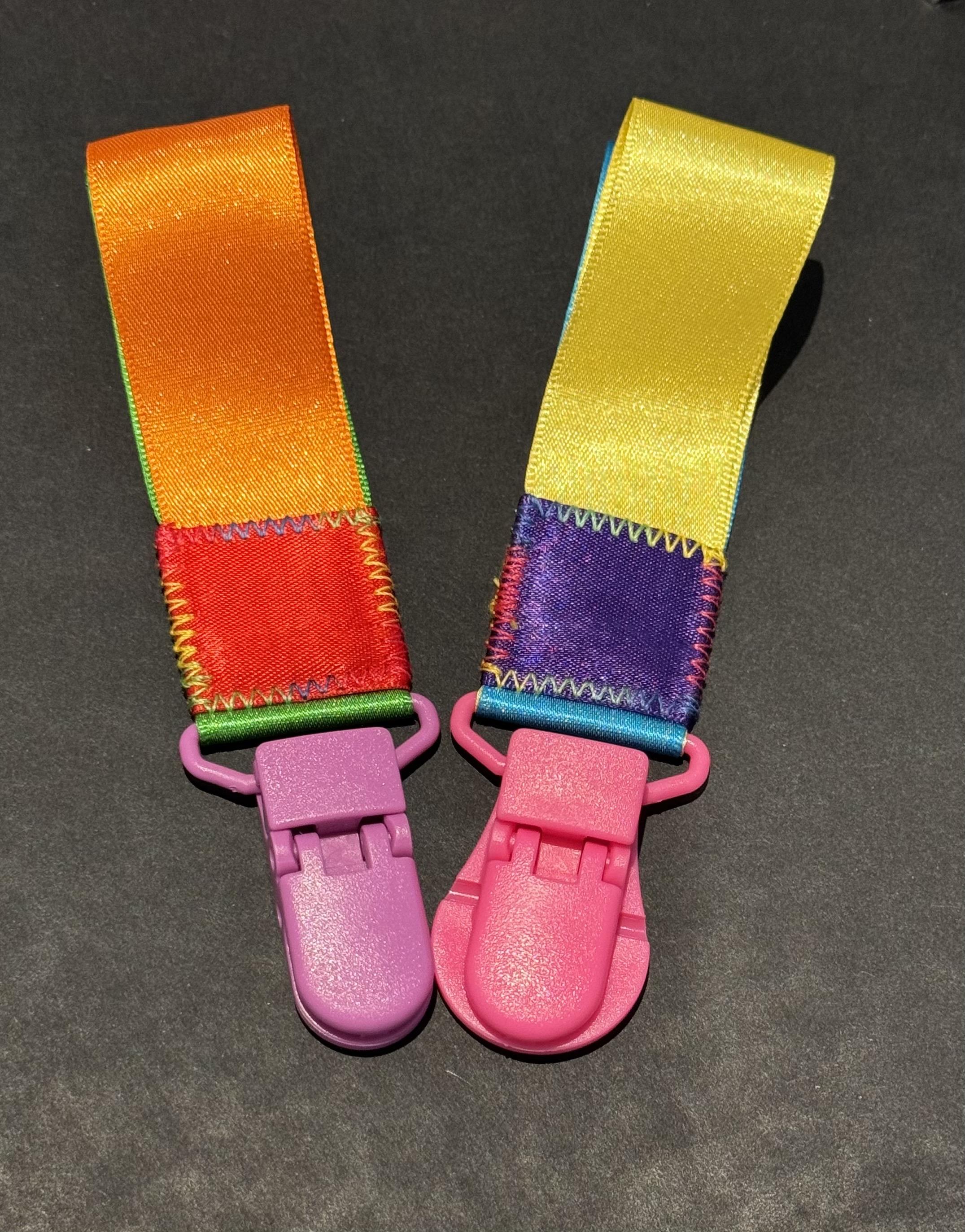 Fidget toys made from satin ribbon and attached to colourful plastic clips